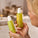A person holding two bottles from Tropic’s Desert Lime & Ginger Limited Edition collection, including the energising hand wash and enveloping hand cream, both in green pump bottles with a fresh, citrus-inspired design.